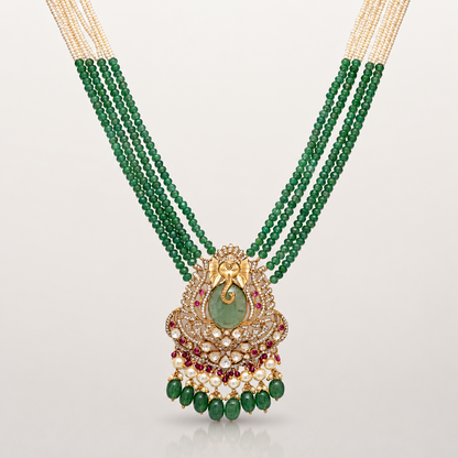 Ganesha pendant with green coloured stones and intricate gold-toned detailing