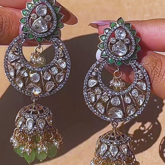 Gold-plated 925 silver crescent kundan jhumka earrings with lotus motifs, green gemstone beads, pearls, and zircon accents for festive and wedding wear